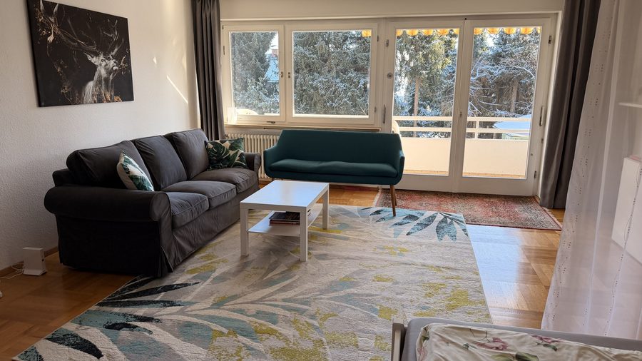 Wohnbereich des Apartments Rot mit Sofa und Blick zum Balkon