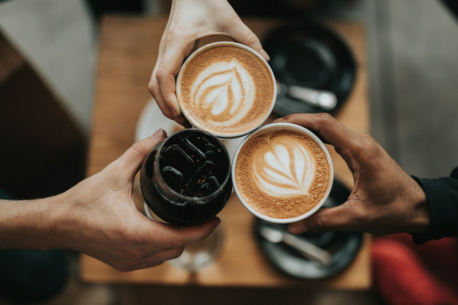 Herzlich willkommen: zwei Gäste stoßen mit Kaffee an